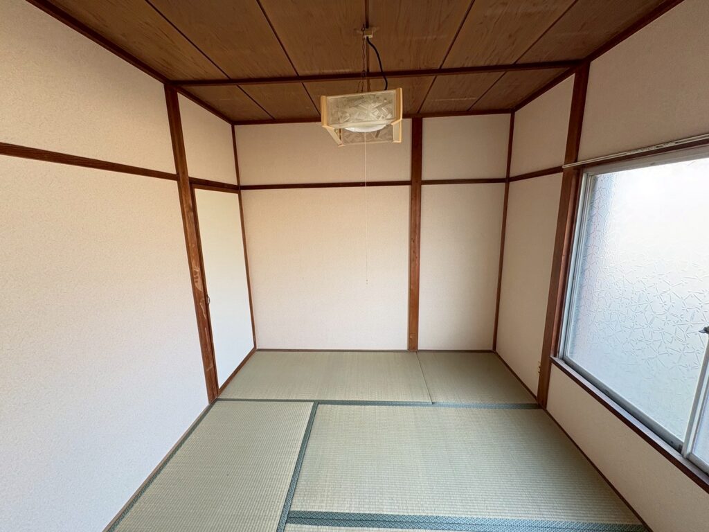 リフォーム前の和室。畳敷きの床と木枠の天井、障子風のすりガラス窓がある昔ながらの一室